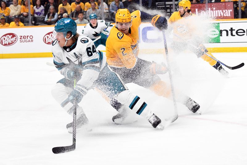 Mar 19, 2024; Nashville, Tennessee, USA; San Jose Sharks center Mikael Granlund (64) stops to pass the puck as he is defended by Nashville Predators defenseman Luke Schenn (2) during the second period at Bridgestone Arena. Mandatory Credit: Christopher Hanewinckel-USA TODAY Sports