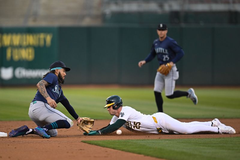 Sep 4, 2024; Oakland, California, USA; Oakland Athletics designated hitter Brent Rooker (25) gets tagged out by Seattle Mariners shortstop J.P. Crawford (3) while attempting to steal second base in the first inning at Oakland-Alameda County Coliseum. Mandatory Credit: Eakin Howard-Imagn Images
