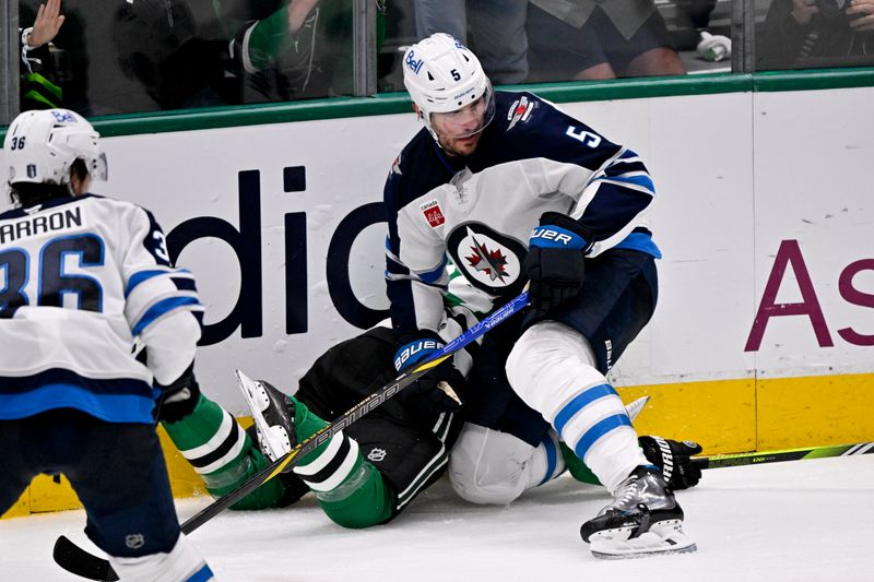 May 17, 2025; Dallas, Texas, USA; Winnipeg Jets defenseman Luke Schenn (5) checks Dallas Stars center Mikael Granlund (64) during the second period in game six of the second round of the 2025 Stanley Cup Playoffs at American Airlines Center. Mandatory Credit: Jerome Miron-Imagn Images