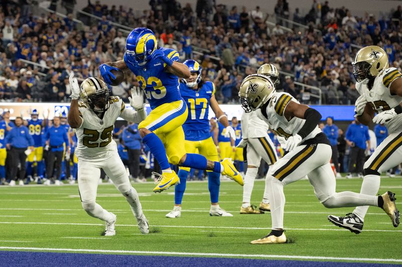 Los Angeles Rams running back Kyren Williams (23) runs with the ball to score a touchdown over New Orleans Saints cornerback Paulson Adebo (29) during an NFL football game, Thursday, Dec. 21, 2023, in Inglewood, Calif. (AP Photo/Kyusung Gong)