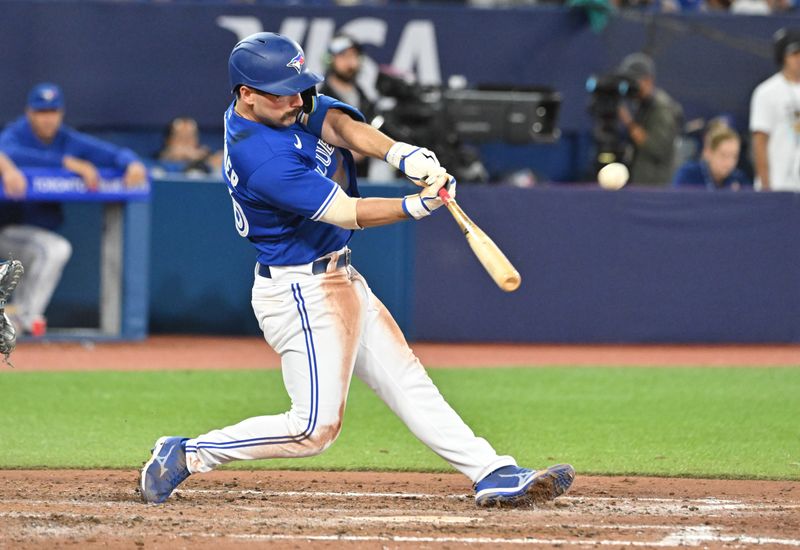 Sep 12, 2023; Toronto, Ontario, CAN;  Toronto Blue Jays second baseman Davis Schneider (36) hits a sacrifice fly against the Texas Rangers in the seventh inning at Rogers Centre. Mandatory Credit: Dan Hamilton-USA TODAY Sports