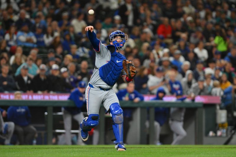 Sep 14, 2024; Seattle, Washington, USA; Texas Rangers catcher Carson Kelly (18) throws to first base for a force out against the Seattle Mariners during the fifth inning at T-Mobile Park. Mandatory Credit: Steven Bisig-Imagn Images