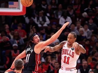 CHICAGO, ILLINOIS - NOVEMBER 20:  DeMar DeRozan #11 of the Chicago Bulls passes the ball against Jaime Jaquez Jr. #11 of the Miami Heat during the first half at the United Center on November 20, 2023 in Chicago, Illinois. NOTE TO USER: User expressly acknowledges and agrees that, by downloading and or using this photograph, User is consenting to the terms and conditions of the Getty Images License Agreement. (Photo by Justin Casterline/Getty Images)