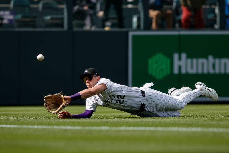 Apr 10, 2024; Denver, Colorado, USA; Colorado Rockies left fielder Nolan Jones (22) dives for a fly ball but is unable to make the catch in the ninth inning against the Arizona Diamondbacks at Coors Field. Mandatory Credit: Isaiah J. Downing-USA TODAY Sports