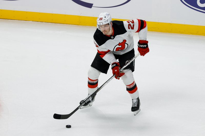 Feb 26, 2025; Denver, Colorado, USA; New Jersey Devils defenseman Brett Pesce (22) controls the puck in the first period against the Colorado Avalanche at Ball Arena. Mandatory Credit: Isaiah J. Downing-Imagn Images
