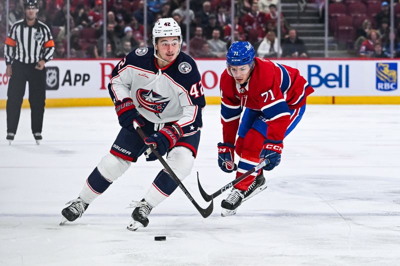 Mar 12, 2024; Montreal, Quebec, CAN; Columbus Blue Jackets center Alexandre Texier (42) plays the puck against Montreal Canadiens center Jake Evans (71) during the second period at Bell Centre. Mandatory Credit: David Kirouac-USA TODAY Sports