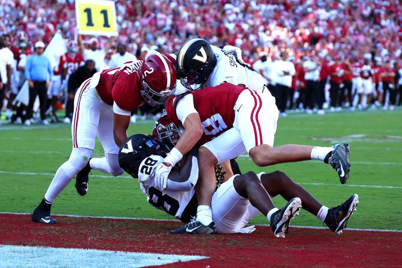 Oct 4, 2025; Tuscaloosa, Alabama, USA; Vanderbilt Commodores running back Sedrick Alexander (28) pushes past Alabama Crimson Tide defensive back Zabien Brown (2) and defensive back Bray Hubbard (18) into the endzone for a touchdown during the second quarter at Saban Field at Bryant-Denny Stadium. Mandatory Credit: David Leong-Imagn Images