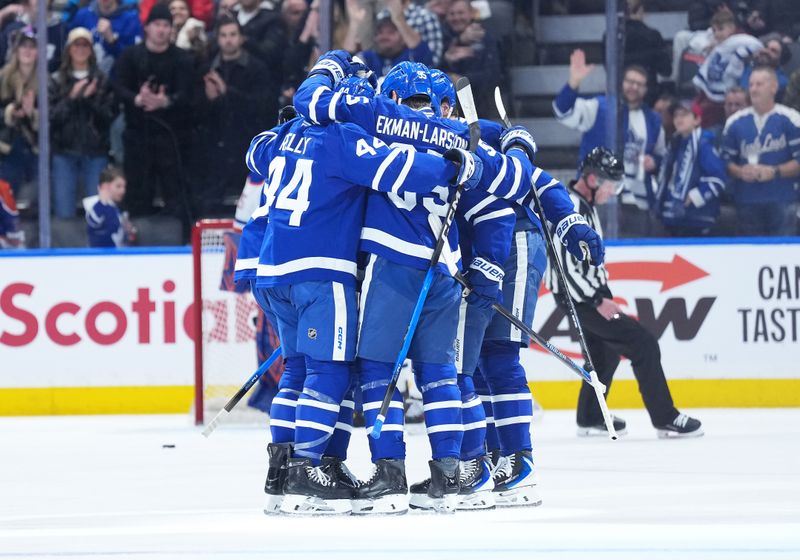 Dec 13, 2025; Toronto, Ontario, CAN; Toronto Maple Leafs defenseman Oliver Ekman-Larsson (95) scores a goal and celebrates with defenseman Morgan Rielly (44) against the Edmonton Oilers during the second period at Scotiabank Arena. Mandatory Credit: Nick Turchiaro-Imagn Images