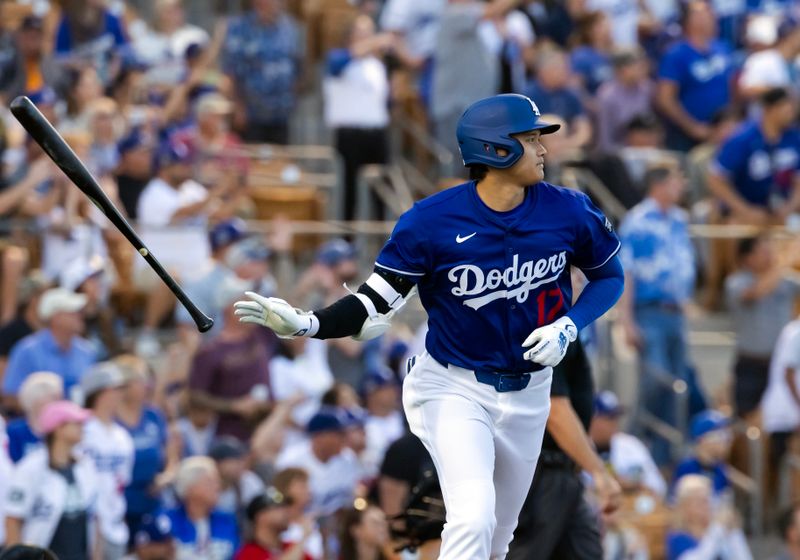 Feb 28, 2025; Phoenix, Arizona, USA; Los Angeles Dodgers designated hitter Shohei Ohtani (17) tosses his bat affter hitting a leadoff home run against the Los Angeles Angels during a spring training game at Camelback Ranch-Glendale. Mandatory Credit: Mark J. Rebilas-Imagn Images
