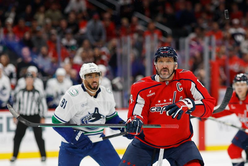 Oct 19, 2025; Washington, District of Columbia, USA; Washington Capitals left wing Alex Ovechkin (8) watches the puck deflect into the air in front of Vancouver Canucks left wing Evander Kane (91) during the third period  at Capital One Arena. Mandatory Credit: Geoff Burke-Imagn Images