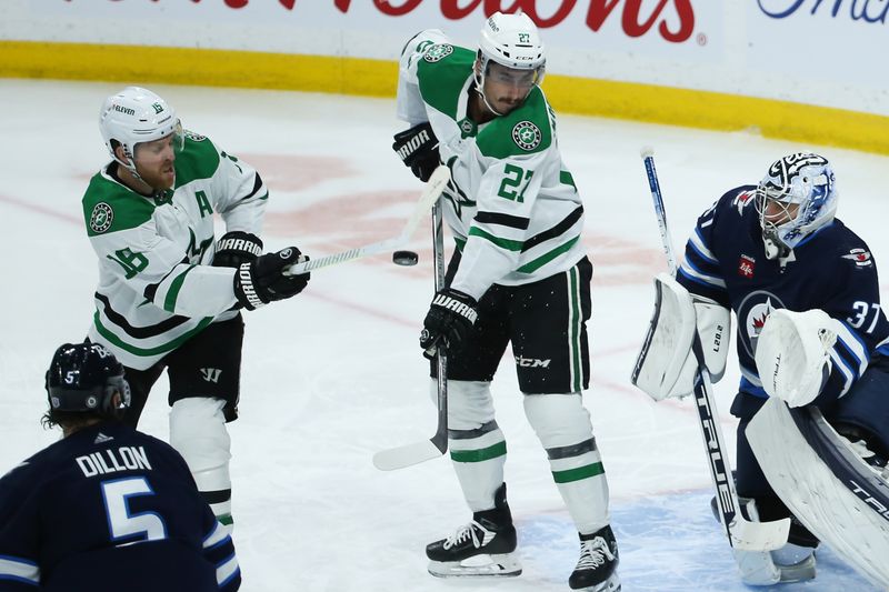 Nov 11, 2023; Winnipeg, Manitoba, CAN;  Dallas Stars forward Sam Steel (18) tries to deflect the puck pact Winnipeg Jets goalie Connor Hellebuyck (37) during the third period at Canada Life Centre. Mandatory Credit: Terrence Lee-USA TODAY Sports