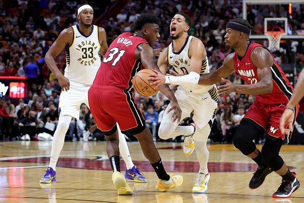 MIAMI, FLORIDA - NOVEMBER 30: Tyrese Haliburton #0 of the Indiana Pacers drives against Thomas Bryant #31 and Jimmy Butler #22 of the Miami Heat during the third quarter of the game at Kaseya Center on November 30, 2023 in Miami, Florida. NOTE TO USER: User expressly acknowledges and agrees that, by downloading and or using this photograph, User is consenting to the terms and conditions of the Getty Images License Agreement. (Photo by Megan Briggs/Getty Images)