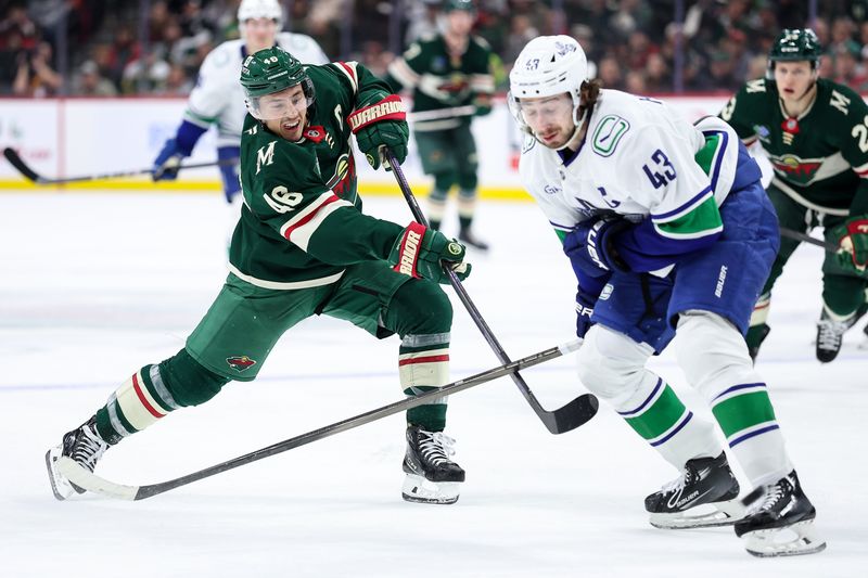 Dec 3, 2024; Saint Paul, Minnesota, USA; Minnesota Wild defenseman Jared Spurgeon (46) shoots as Vancouver Canucks defenseman Quinn Hughes (43) defends during the third period at Xcel Energy Center. Mandatory Credit: Matt Krohn-Imagn Images