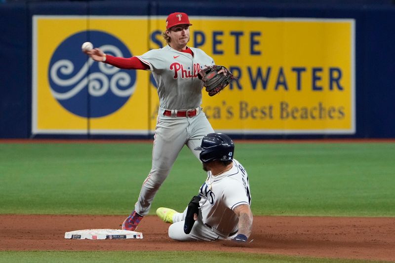 Jul 4, 2023; St. Petersburg, Florida, USA; Philadelphia Phillies shortstop Trea Turner (7) throws to first base as Tampa Bay Rays designated hitter Harold Ramirez (43) slides into second base on a ball hit by left fielder Randy Arozarena (not shown) during the eighth inning at Tropicana Field. Mandatory Credit: Dave Nelson-USA TODAY Sports