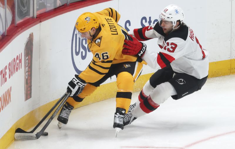 Feb 26, 2026; Pittsburgh, Pennsylvania, USA;  Pittsburgh Penguins center Blake Lizotte (46) handles the puck against pressure from New Jersey Devils center Nico Hischier (13) during the second period at PPG Paints Arena. Mandatory Credit: Charles LeClaire-Imagn Images