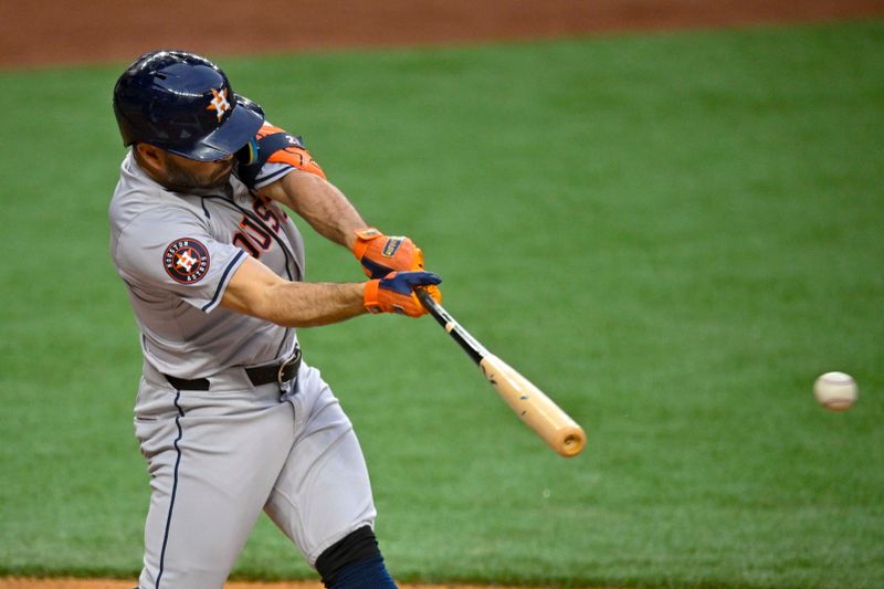 Apr 5, 2024; Arlington, Texas, USA; Houston Astros second base Jose Altuve (27) hits a single against the Texas Rangers during the first inning at Globe Life Field. Mandatory Credit: Jerome Miron-USA TODAY Sports