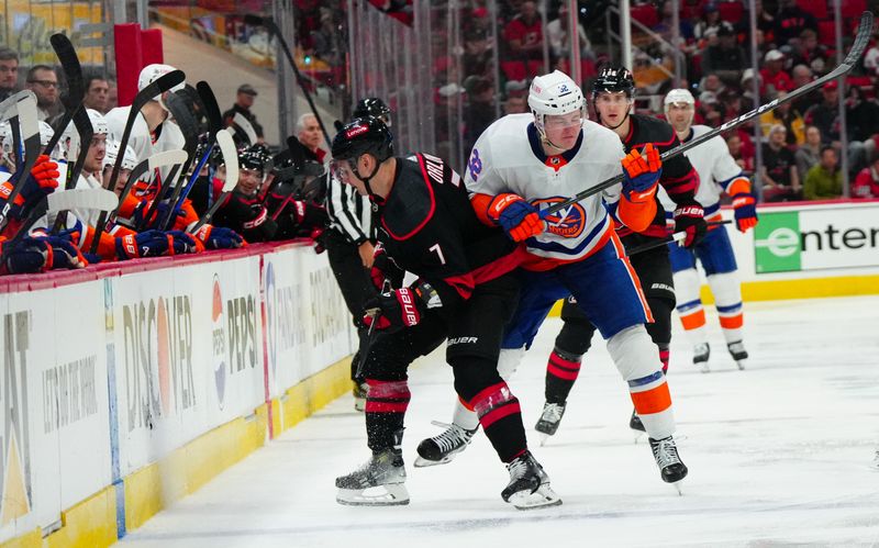 Apr 20, 2024; Raleigh, North Carolina, USA; Carolina Hurricanes defenseman Dmitry Orlov (7) checks New York Islanders center Kyle MacLean (32) during the second period in game one of the first round of the 2024 Stanley Cup Playoffs at PNC Arena. Mandatory Credit: James Guillory-USA TODAY Sports