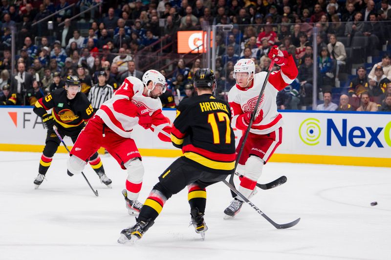 Feb 15, 2024; Vancouver, British Columbia, CAN; Detroit Red Wings forward Lucas Raymond (23) watches as forward Dylan Larkin (71) shoots around Vancouver Canucks defenseman Filip Hronek (17) in the first period at Rogers Arena. Mandatory Credit: Bob Frid-USA TODAY Sports