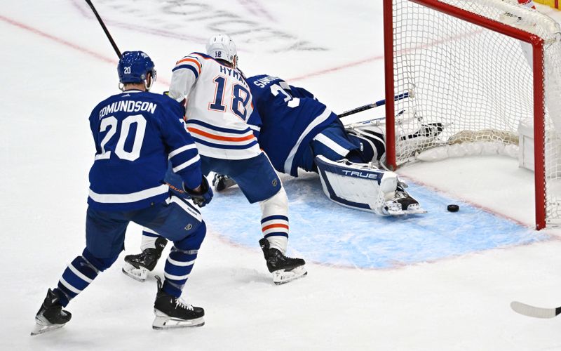 Mar 23, 2024; Toronto, Ontario, CAN; Edmonton Oilers forward Zach Hyman (18) and Toronto Maple Leafs defenseman Joel Edmundson (20) watch the puck enter the net on a shot by Oilers forward Leon Draisaitl (not shown) in the third period at Scotiabank Arena. Maple Leafs goalie Ilya Samsonov (35) was injured on the play. Mandatory Credit: Dan Hamilton-USA TODAY Sports