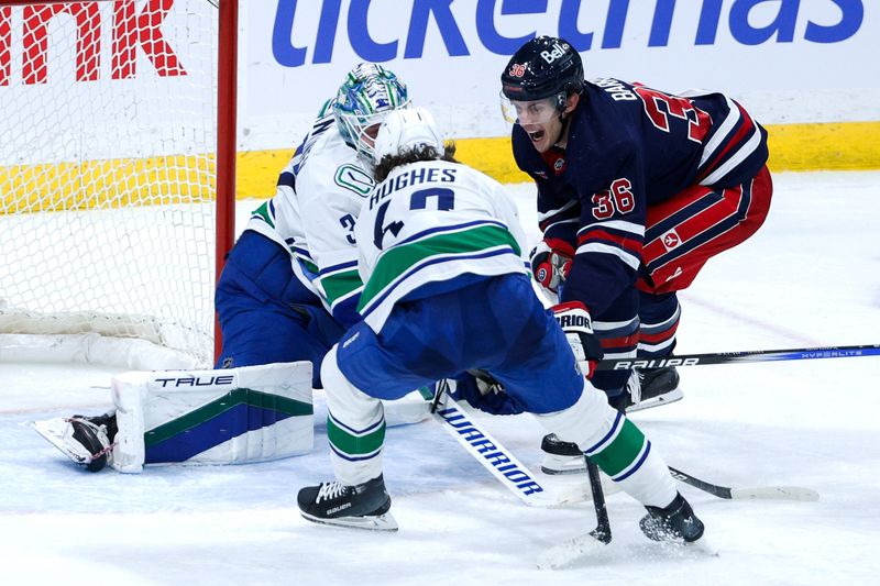 Jan 14, 2025; Winnipeg, Manitoba, CAN;  Winnipeg Jets forward Morgan Barron (36) and Vancouver Canucks defenseman Quinn Hughes (43) fight for puck in front of Vancouver Canucks goalie Kevin Lankinen (32) during the third period at Canada Life Centre. Mandatory Credit: Terrence Lee-Imagn Images