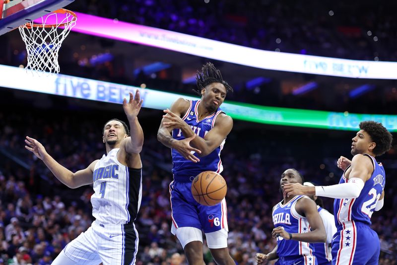 PHILADELPHIA, PENNSYLVANIA - FEBRUARY 01: Jalen Suggs #4 of the Orlando Magic and Tyrese Maxey #0 of the Philadelphia 76ers challenge for the ball during the fourth quarter at Wells Fargo Center on February 01, 2023 in Philadelphia, Pennsylvania. NOTE TO USER: User expressly acknowledges and agrees that, by downloading and or using this photograph, User is consenting to the terms and conditions of the Getty Images License Agreement. (Photo by Tim Nwachukwu/Getty Images)