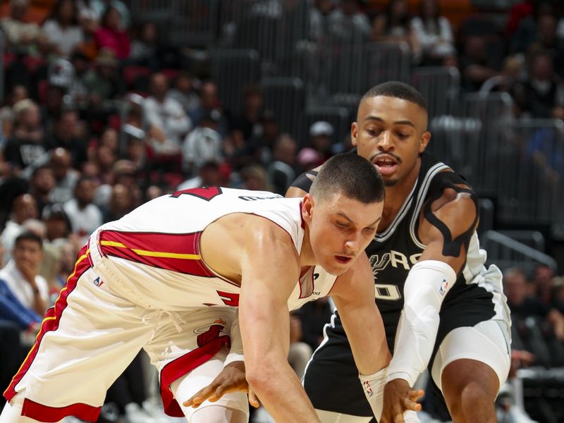 MIAMI, FL - OCTOBER 15: Tyler Herro #14 of the Miami Heat and Keldon Johnson #0 of the San Antonio Spurs go after a loose ball during the game on October 15, 2024 at Kaseya Center in Miami, Florida. NOTE TO USER: User expressly acknowledges and agrees that, by downloading and or using this Photograph, user is consenting to the terms and conditions of the Getty Images License Agreement. Mandatory Copyright Notice: Copyright 2024 NBAE (Photo by Issac Baldizon/NBAE via Getty Images)