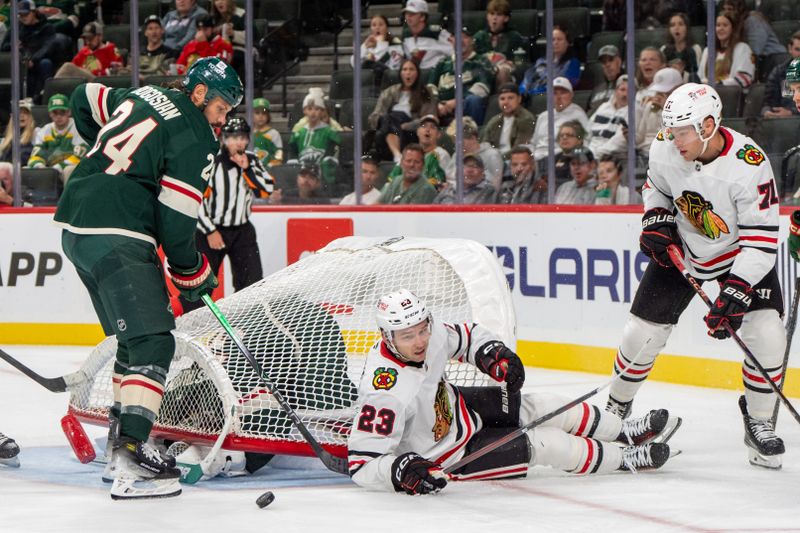 Oct 1, 2024; Saint Paul, Minnesota, USA; Chicago Blackhawks center Philipp Kurashev (23) and Minnesota Wild defenseman Zach Bogosian (27) after colliding into the goal in the third period at Xcel Energy Center. Mandatory Credit: Matt Blewett-Imagn Images