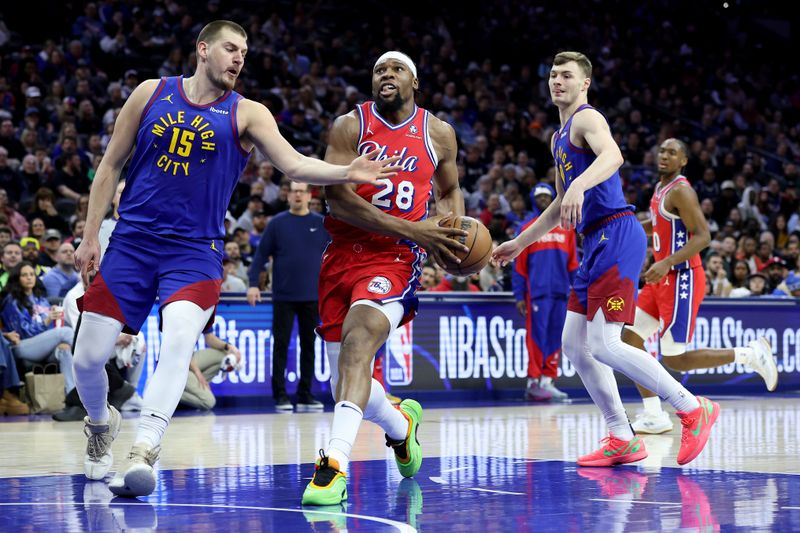 PHILADELPHIA, PENNSYLVANIA - JANUARY 31: Guerschon Yabusele #28 of the Philadelphia 76ers drives to the basket against Nikola Jokic #15 of the Denver Nuggets during the first half at the Wells Fargo Center on January 31, 2025 in Philadelphia, Pennsylvania. NOTE TO USER: User expressly acknowledges and agrees that, by downloading and or using this photograph, User is consenting to the terms and conditions of the Getty Images License Agreement. (Photo by Emilee Chinn/Getty Images)