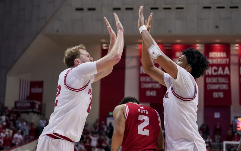 Feb 7, 2026; Bloomington, Indiana, USA; Indiana Hoosiers forward Tucker DeVries (12) celebrates with Indiana Hoosiers forward Sam Alexis (4) during the second half at Simon Skjodt Assembly Hall. Mandatory Credit: Robert Goddin-Imagn Images