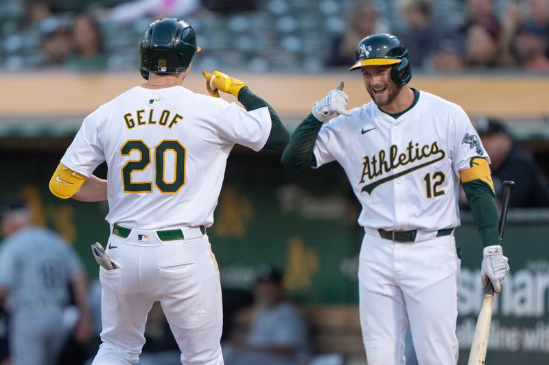 Aug 6, 2024; Oakland, California, USA;  Oakland Athletics shortstop Max Schuemann (12) celebrates with second base Zack Gelof (20) during the fourth inning against the Chicago White Sox at Oakland-Alameda County Coliseum. Mandatory Credit: Stan Szeto-USA TODAY Sports