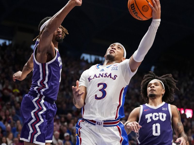 Jan 6, 2024; Lawrence, Kansas, USA; Kansas Jayhawks guard Dajuan Harris Jr. (3) shoots against TCU Horned Frogs forward Xavier Cork (12) and guard Micah Peavy (0) during the second half at Allen Fieldhouse. Mandatory Credit: Jay Biggerstaff-USA TODAY Sports