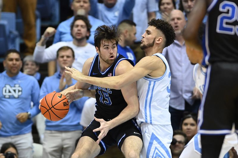 Mar 4, 2023; Chapel Hill, North Carolina, USA; Duke Blue Devils center Ryan Young (15) with the ball as North Carolina Tar Heels forward Pete Nance (32) defends in the second half at Dean E. Smith Center. Mandatory Credit: Bob Donnan-USA TODAY Sports