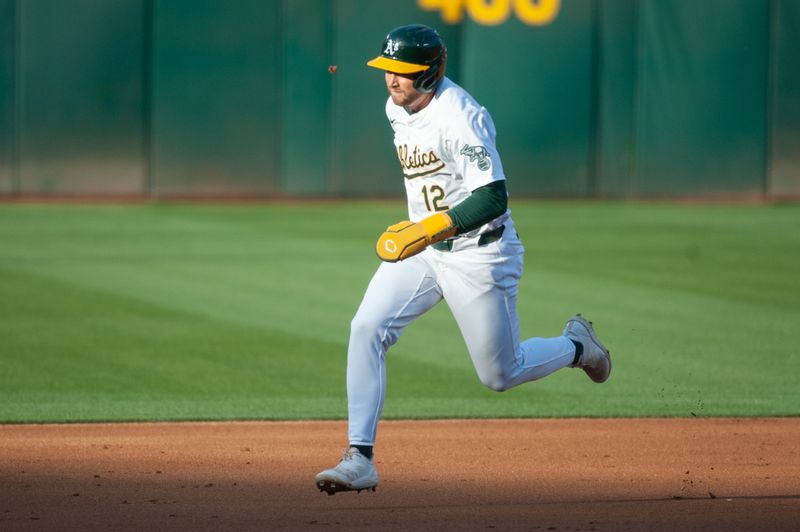 Jun 18, 2024; Oakland, California, USA; Oakland Athletics shortstop Max Schuemann (12) rounds second base on his way to score against the Kansas City Royals during the first inning at Oakland-Alameda County Coliseum. Mandatory Credit: Ed Szczepanski-USA TODAY Sports