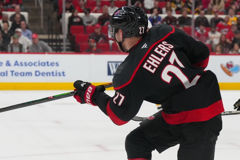 Mar 10, 2026; Raleigh, North Carolina, USA;  Carolina Hurricanes left wing Nikolaj Ehlers (27) takes a shot against the Pittsburgh Penguins during the first period at Lenovo Center. Mandatory Credit: James Guillory-Imagn Images