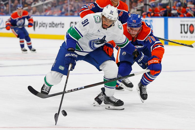 Oct 11, 2025; Edmonton, Alberta, CAN; Vancouver Canucks forward Evander Kane (91) and Edmonton Oilers defensemen Alec Regula (75) chases a loose puck during the second period at Rogers Place. Mandatory Credit: Perry Nelson-Imagn Images