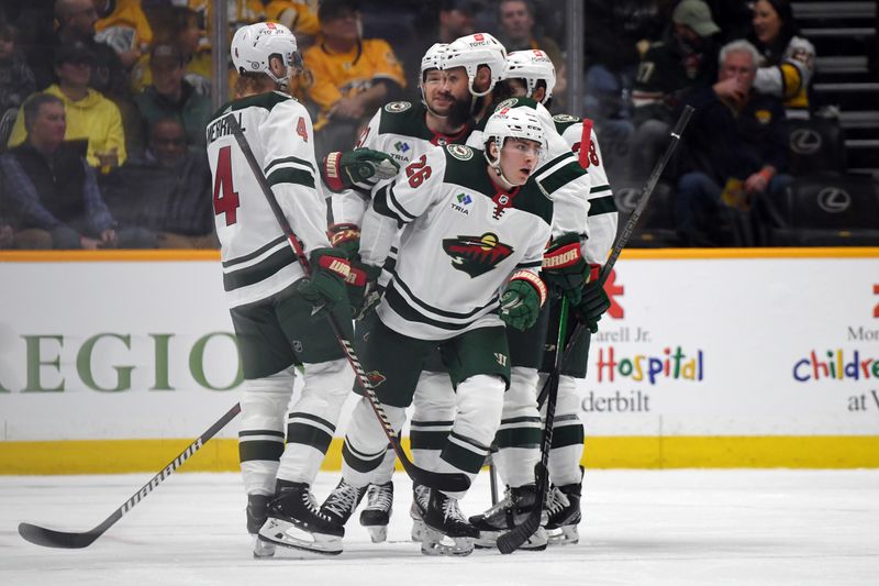 Feb 29, 2024; Nashville, Tennessee, USA; Minnesota Wild center Connor Dewar (26) celebrates with teammates after a goal during the first period against the Nashville Predators at Bridgestone Arena. Mandatory Credit: Christopher Hanewinckel-USA TODAY Sports