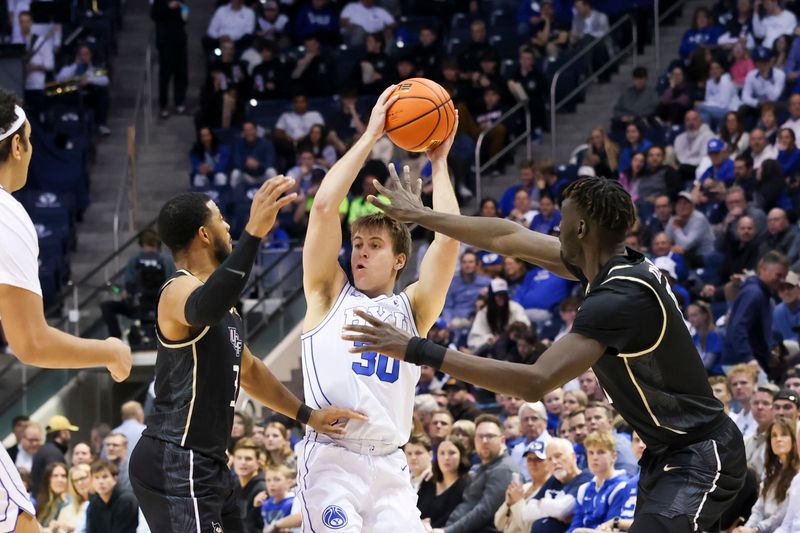 Feb 13, 2024; Provo, Utah, USA; Brigham Young Cougars guard Dallin Hall (30) splits defenders Central Florida Knights guard Darius Johnson (3) and forward C.J. Walker (right) during the second half at Marriott Center. Mandatory Credit: Rob Gray-USA TODAY Sports