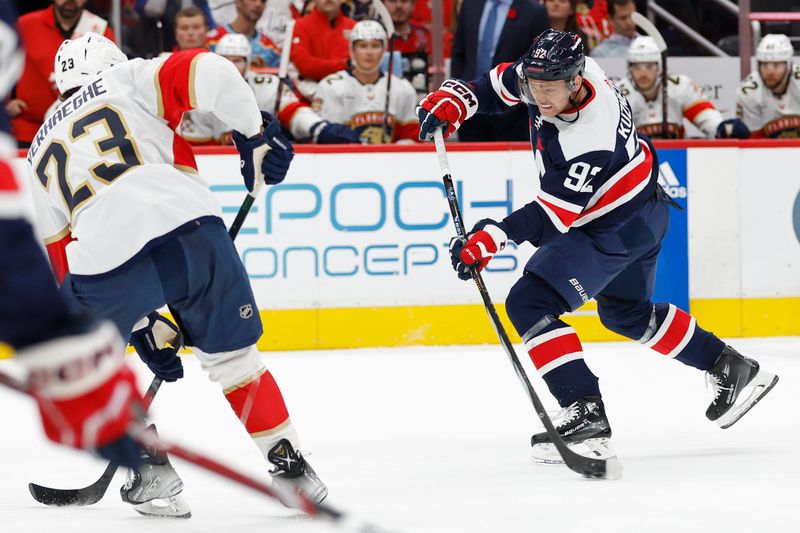 Nov 8, 2023; Washington, District of Columbia, USA; Washington Capitals center Evgeny Kuznetsov (92) shoots the puck as Florida Panthers center Carter Verhaeghe (23) defends in the first period at Capital One Arena. Mandatory Credit: Geoff Burke-USA TODAY Sports