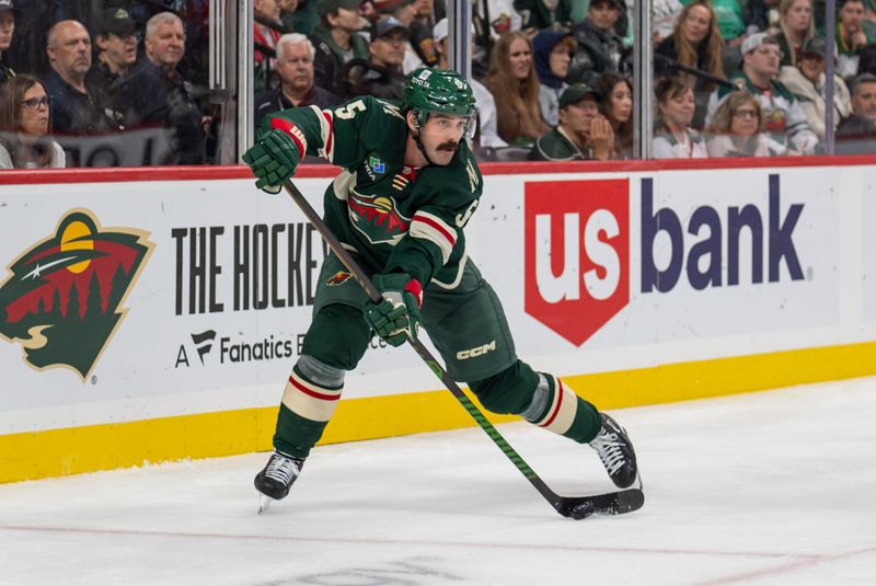 Oct 12, 2024; Saint Paul, Minnesota, USA; Minnesota Wild defenseman Jake Middleton (5) clears the puck against the Seattle Kraken in the third period at Xcel Energy Center. Mandatory Credit: Matt Blewett-Imagn Images