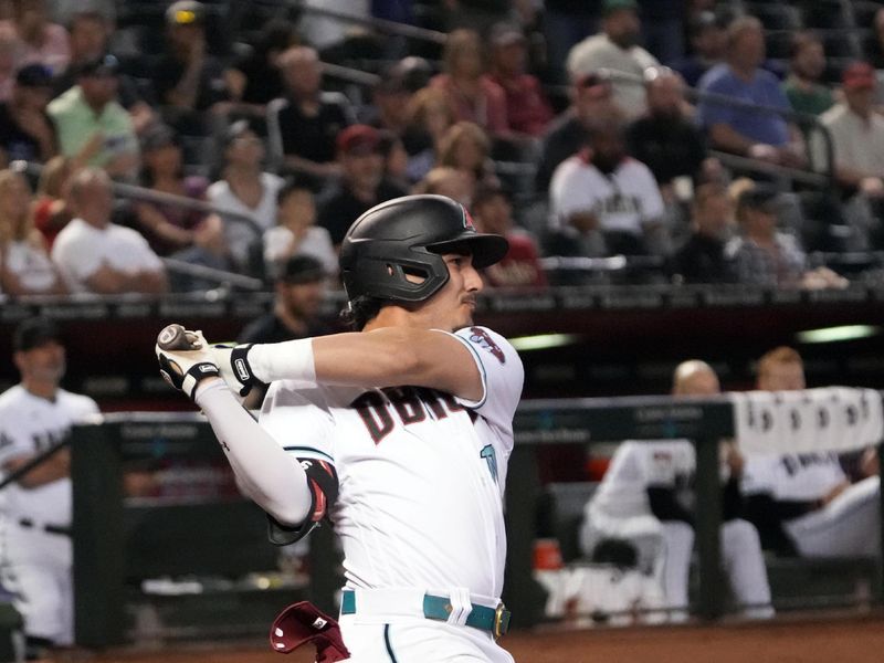 Apr 25, 2023; Phoenix, Arizona, USA; Arizona Diamondbacks third baseman Josh Rojas (10) hits a sacrifice fly RBI against the Kansas City Royals during the seventh inning at Chase Field. Mandatory Credit: Joe Camporeale-USA TODAY Sports