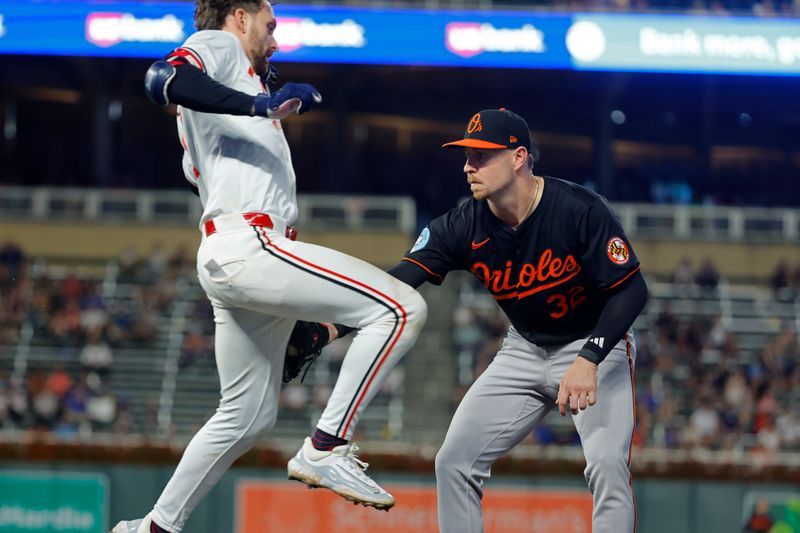 Sep 28, 2024; Minneapolis, Minnesota, USA; Baltimore Orioles first baseman Ryan O'Hearn (32) tags out Minnesota Twins second baseman Edouard Julien (47) on a ground ball in the eighth inning at Target Field. Mandatory Credit: Bruce Kluckhohn-Imagn Images