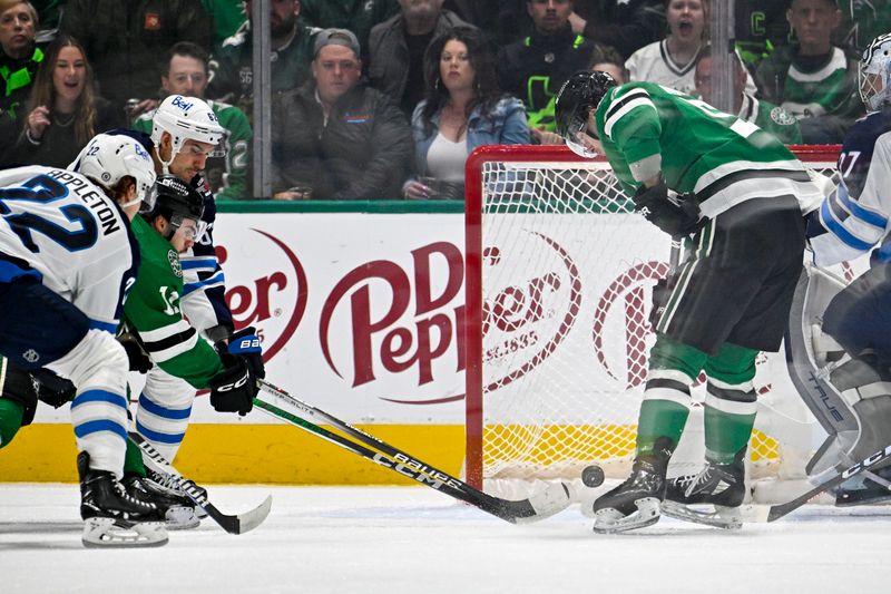Feb 29, 2024; Dallas, Texas, USA;Dallas Stars center Logan Stankoven (11) scores a goal past Winnipeg Jets goaltender Connor Hellebuyck (37) during the first period at the American Airlines Center. Mandatory Credit: Jerome Miron-USA TODAY Sports