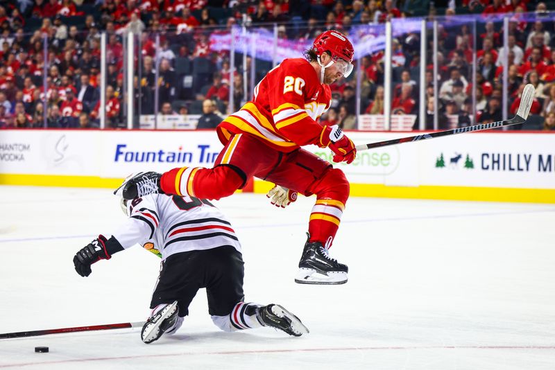 Oct 15, 2024; Calgary, Alberta, CAN; Calgary Flames center Blake Coleman (20) jumps over Chicago Blackhawks center Teuvo Teravainen (86) during the third period at Scotiabank Saddledome. Mandatory Credit: Sergei Belski-Imagn Images