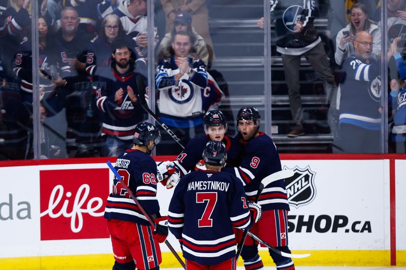 Oct 18, 2024; Winnipeg, Manitoba, CAN;  Winnipeg Jets forward Cole Perfetti (91) is congratulated by his teammates on his goal against the San Jose Sharks during the third period at Canada Life Centre. Mandatory Credit: Terrence Lee-Imagn Images