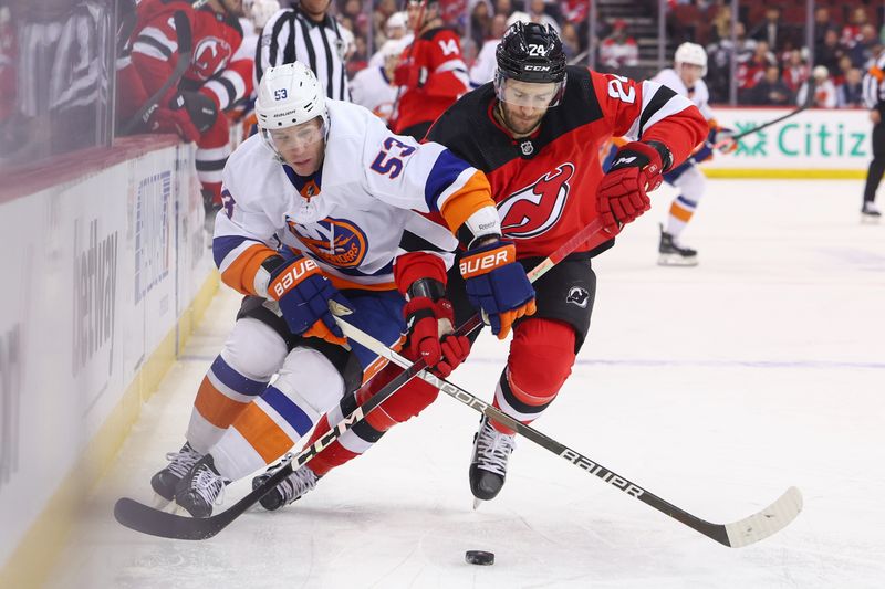 Nov 28, 2023; Newark, New Jersey, USA; New York Islanders center Casey Cizikas (53) and New Jersey Devils defenseman Colin Miller (24) battle for the puck during the first period at Prudential Center. Mandatory Credit: Ed Mulholland-USA TODAY Sports