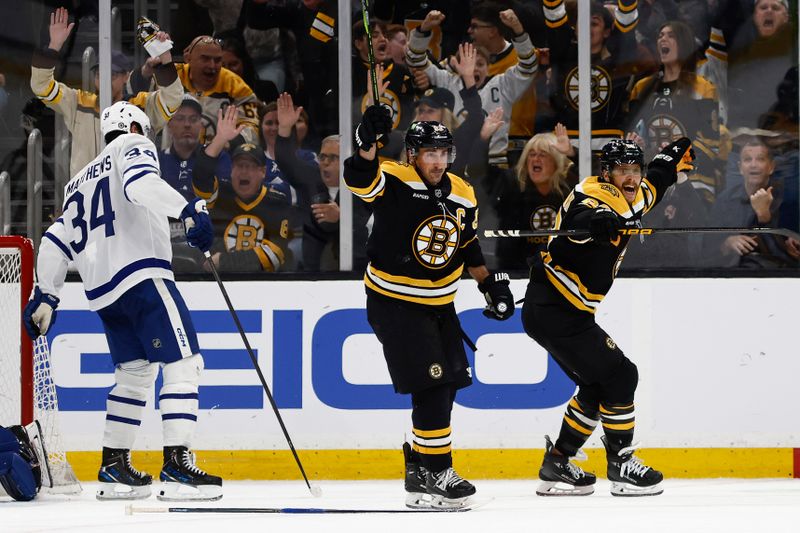 Oct 26, 2024; Boston, Massachusetts, USA; Boston Bruins right wing David Pastrnak (88) (right) and left wing Brad Marchand (63) celebrate the Bruins game winning overtime goal as Toronto Maple Leafs center Auston Matthews (34) skates away during overtime at TD Garden. Mandatory Credit: Winslow Townson-Imagn Images