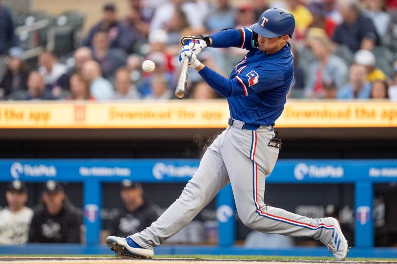 May 24, 2024; Minneapolis, Minnesota, USA; Texas Rangers shortstop Corey Seager (5) hits a home run in the first inning against Minnesota Twins pitcher Bailey Ober (17) at Target Field. Mandatory Credit: Matt Blewett-USA TODAY Sports