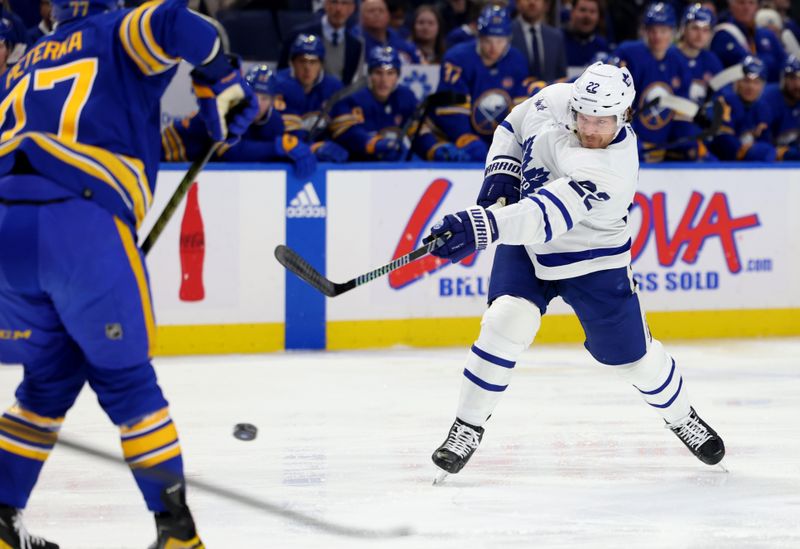 Dec 21, 2023; Buffalo, New York, USA;  Toronto Maple Leafs defenseman Jake McCabe (22) takes a shot on goal during the first period against the Buffalo Sabres at KeyBank Center. Mandatory Credit: Timothy T. Ludwig-USA TODAY Sports