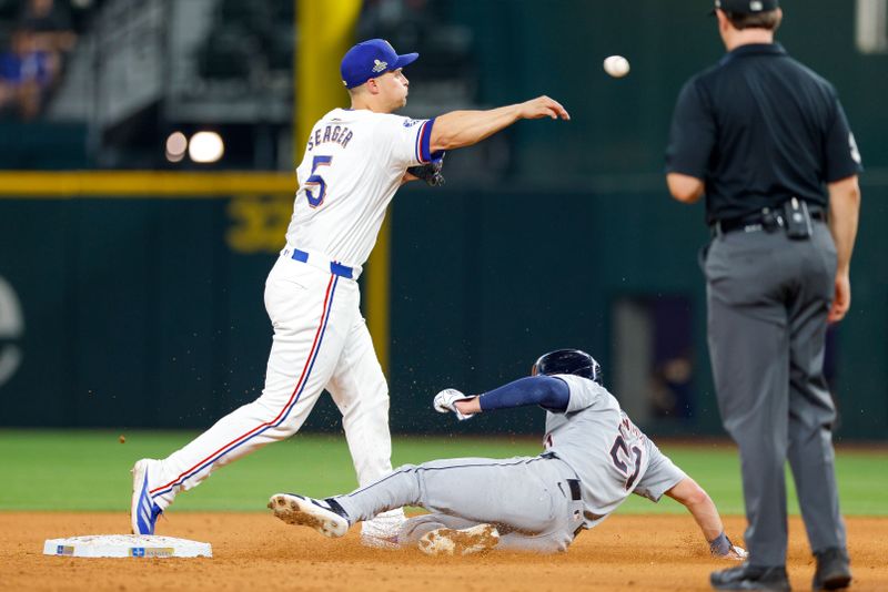 Jun 4, 2024; Arlington, Texas, USA; Texas Rangers shortstop Corey Seager (5) turns a double play with Detroit Tigers outfielder Mark Canha (21) sliding into second base during the eighth inning at Globe Life Field. Mandatory Credit: Andrew Dieb-USA TODAY Sports