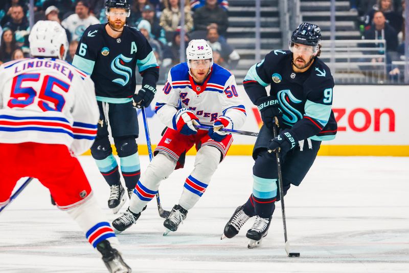 Nov 17, 2024; Seattle, Washington, USA; Seattle Kraken center Chandler Stephenson (9) skates with the puck ahead of New York Rangers left wing Will Cuylle (50) during the first period at Climate Pledge Arena. Mandatory Credit: Joe Nicholson-Imagn Images